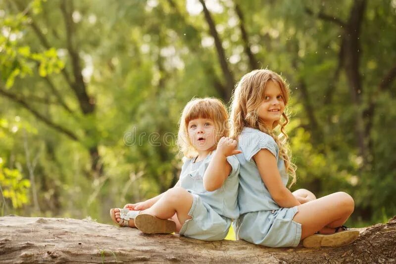 Две девочки в белом платье ругаются. Cute little sister. Две сестрички развлекаются. Дети девочки обнимаются сестренками в кроватке. Сестрёнка бел.