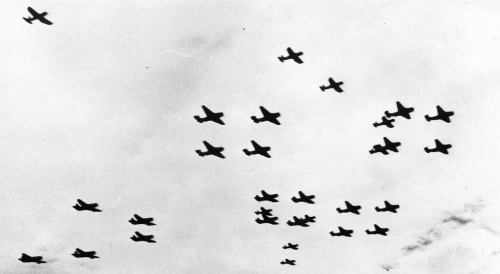 Немецкие самолеты в небе. Самолёт сбрасывает бомбы. Много немецких самолетов.