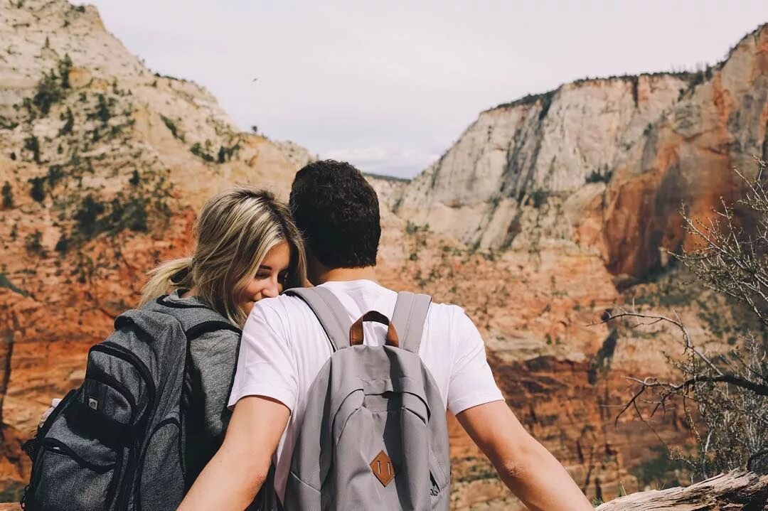 Азиатка в коробке. Рюкзак путешественника. Couple pack. Пара в походе. Двое идут по дороге фото.