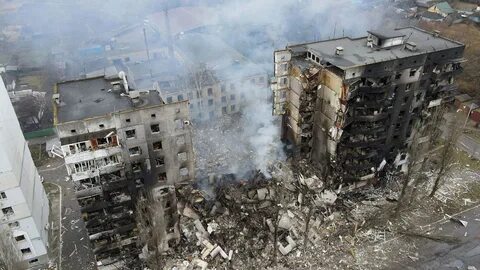 Burnt-out Russian vehicles and the smoking wreckage of buildings can be see...