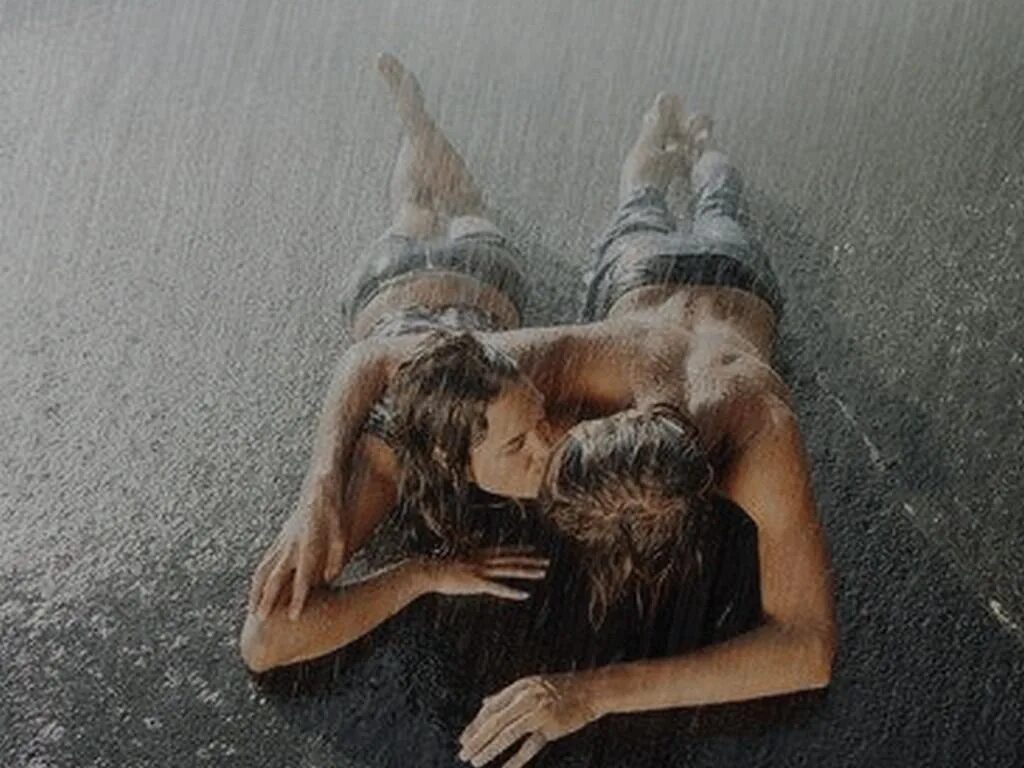 Пара лежит под дождем. Девушка лежит на асфальте под дождем. Поцелуй под дождем. Заниматься любовью.