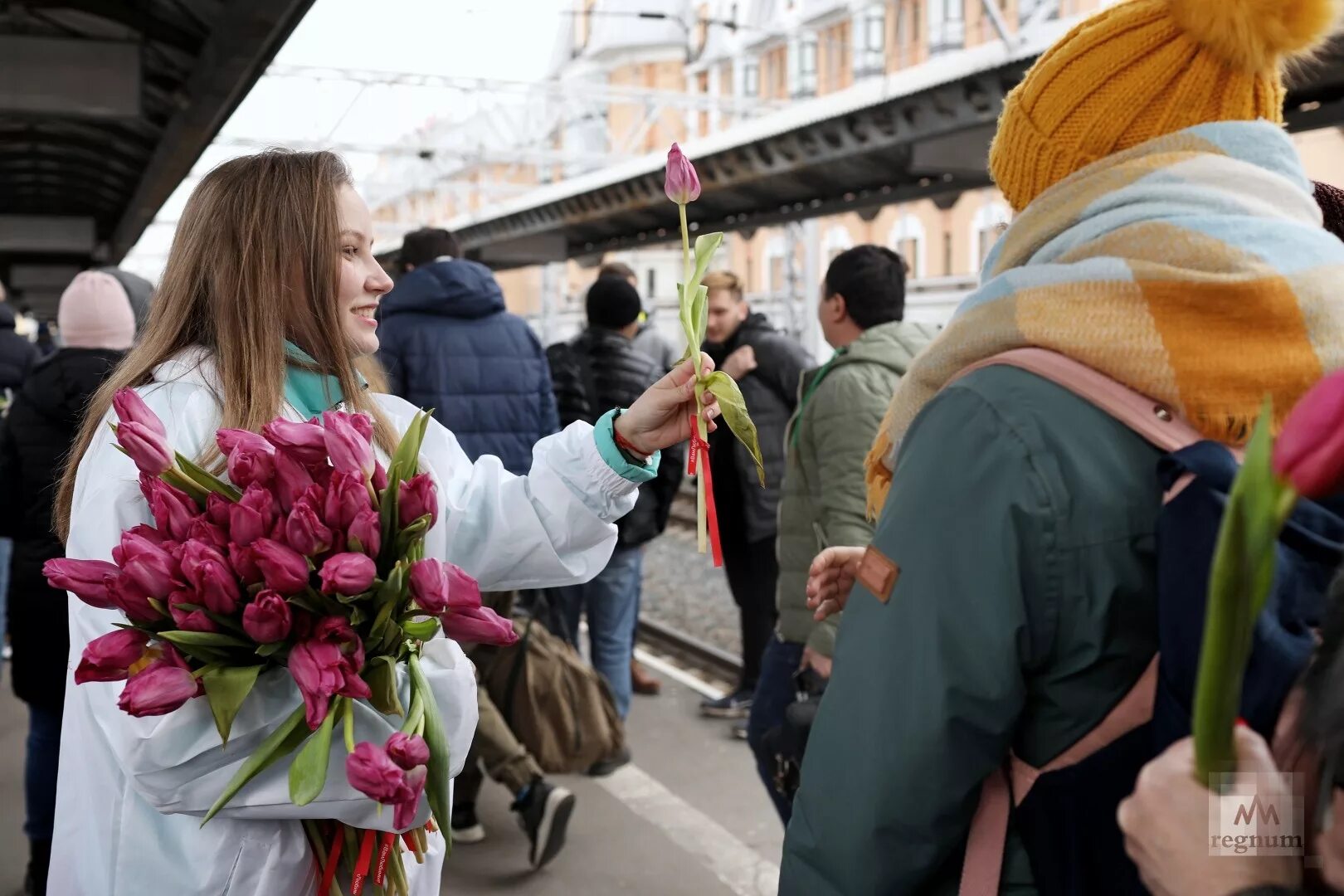 Дарят цветы на улице. Женщина с цветами на вокзале. На улице дарят цветы