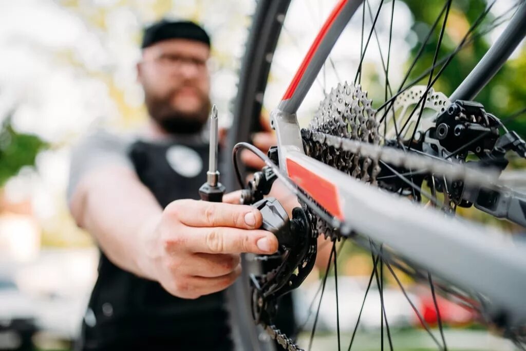 Bike mechanic. Чинит велосипед. Сборщик велосипедов. Отремонтированный велосипед. Обслуживание велосипеда.