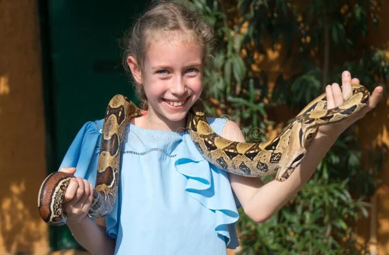 Ребенок держит змею. Дети со змеями. Девочка держит змею. Девушка держит змею в руках. Детская фотосессия со змеями.