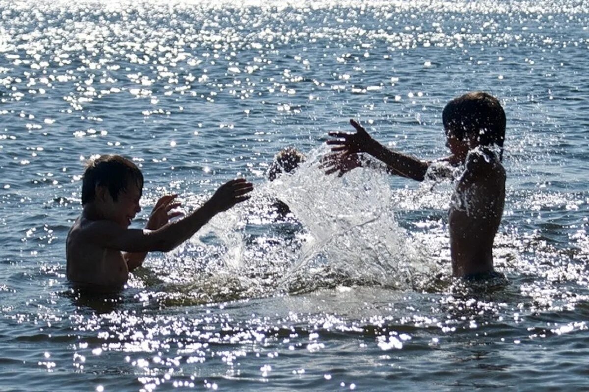 Дети плескаются в воде. Дети купаются в море. Купание в водоемах. Дети на озере.