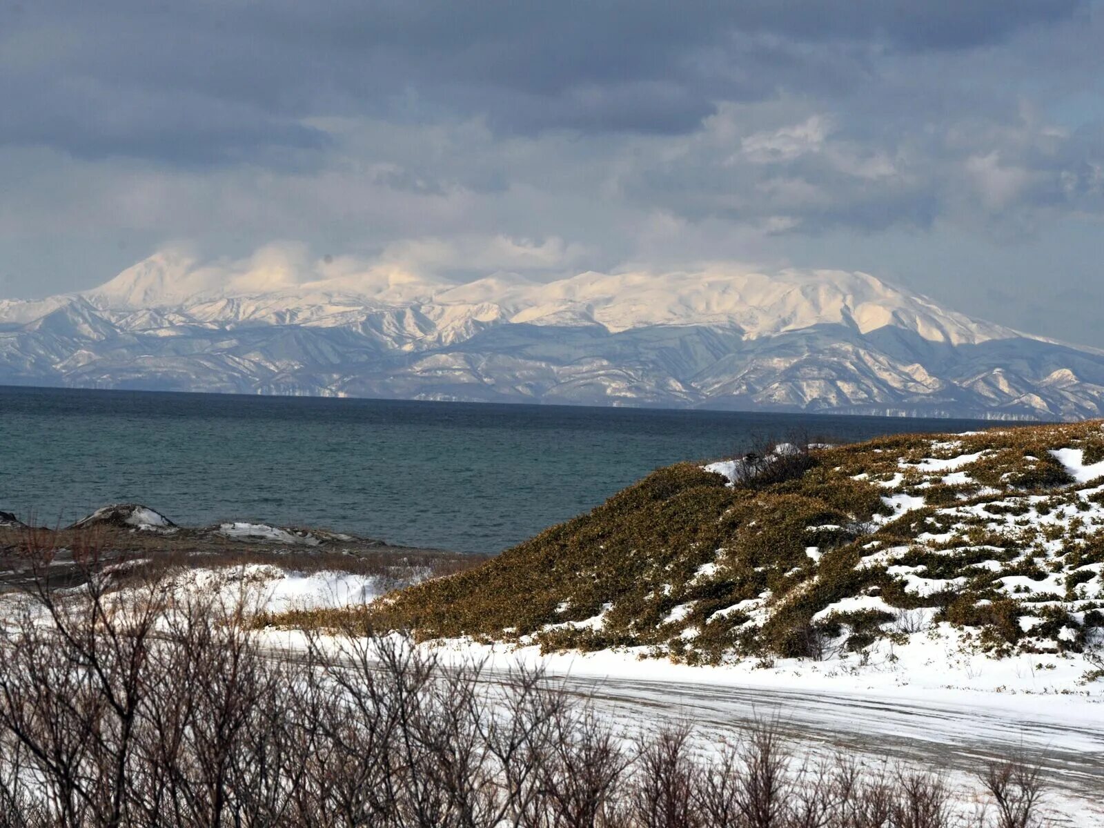 Село курил. Вид на Кунашир с острова Хоккайдо. Остров Кунашир Курильские острова. Вид на остров Хоккайдо с острова Кунашир. Южно Курильск остров Кунашир зимой.