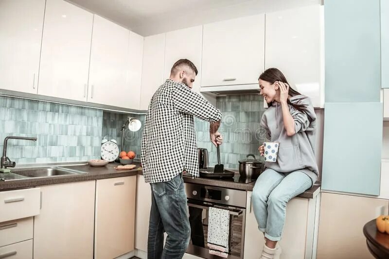 Муж сидит жена готовит. Жена сидит около плиты. Он готовит она сидит рядом. Сидит рядом с мужем дома.
