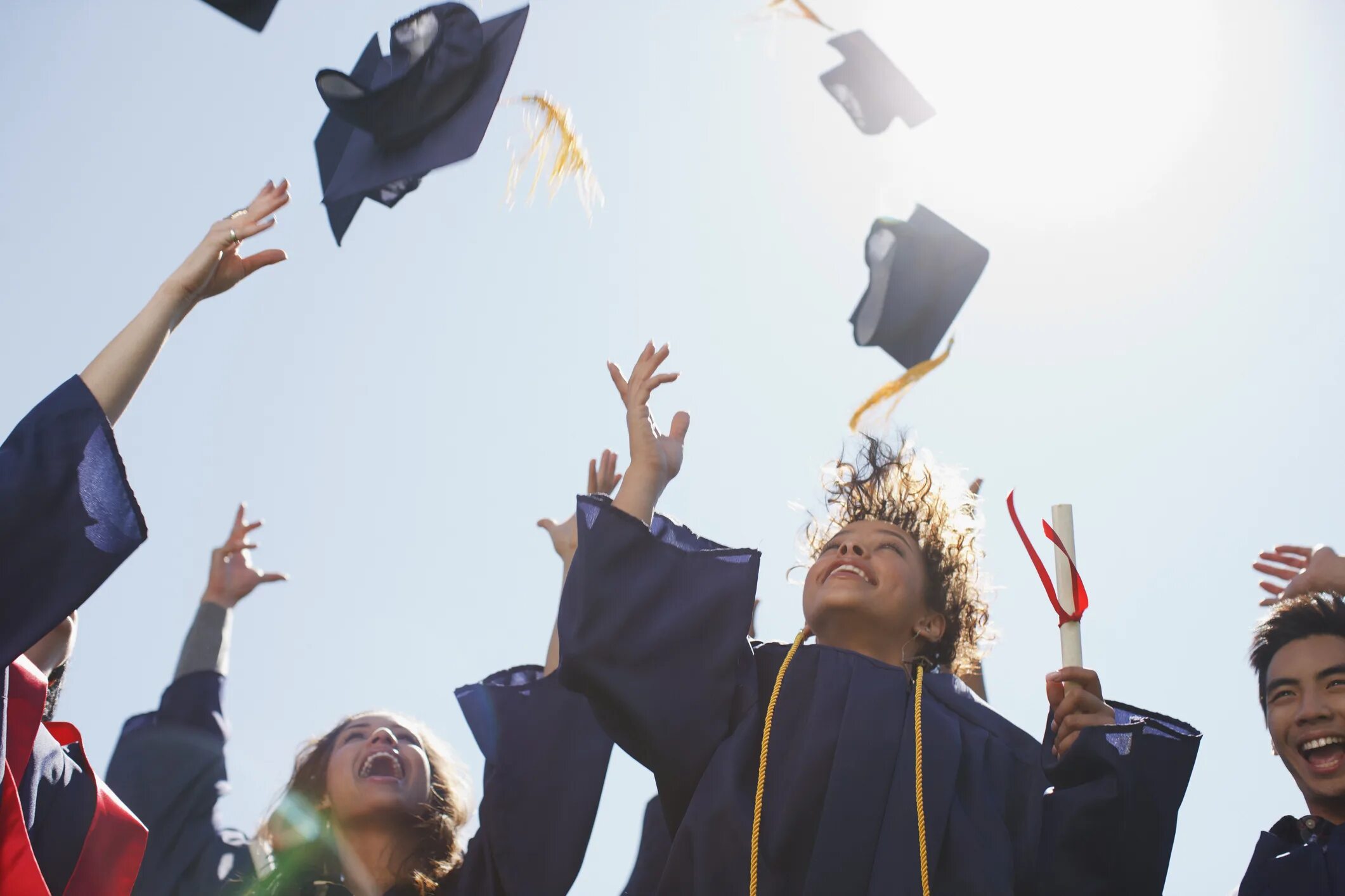 High school graduates. Студенты Австралии. Австралийские выпускники. Шапки выпускников в воздухе. Подбрасывают шапки.