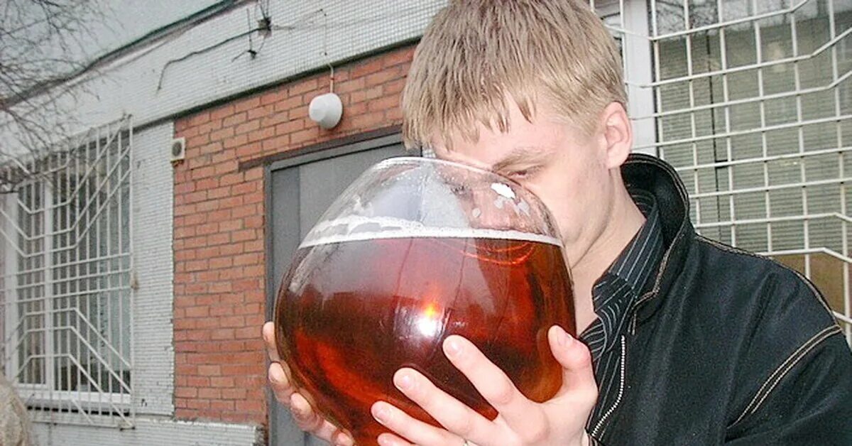 Мужчина поднимает бокал. Рюмка в руке. Пьющий мужчина. Мужчина с рюмкой в руке. Парень с рюмкой.