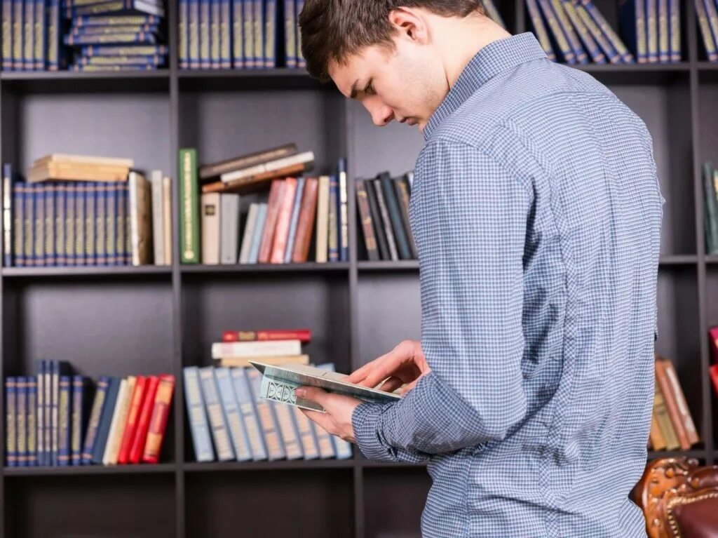Том смотрит в книгу. Человек ищет книгу. Человек ищет информацию. Человек ищет в библиотеке. Человек ищет информацию в книге.