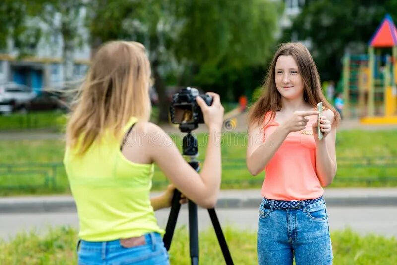 Молодая сняла себя на телефоне. Две девочки снимают видео. 2 Девочки держат телефоны.