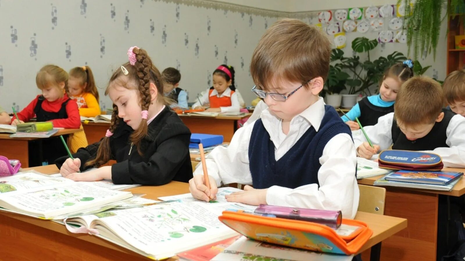 Класс с учениками. Леворукий ребенок. Пишут первоклассники. Пишут первоклассники. Ученик за партой.