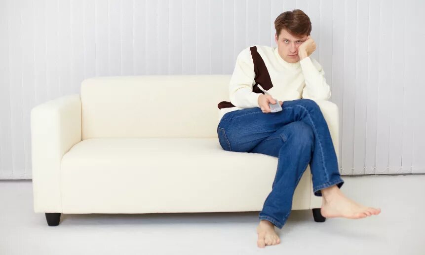 передвигать мебель. мужчина отдыхает на диване. на диване стоящем в углу. мужчина на диване фотосессия. сидит на диване.