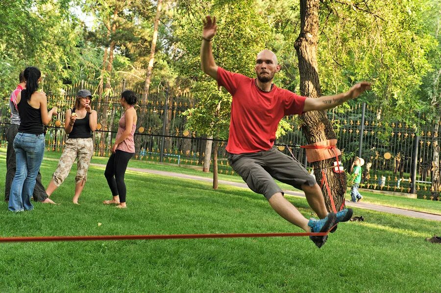 Спор между деревьями. Слэклайн в парке. Слеклайн между деревьями. Хождение по веревке между деревьями. Прыжки через канат.