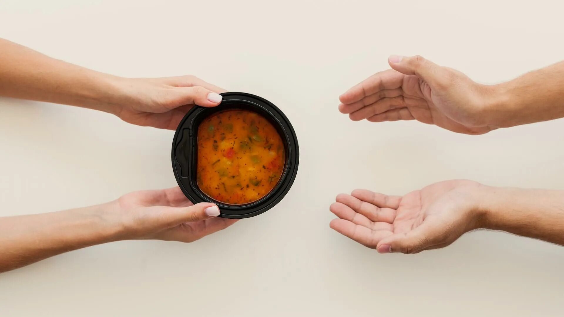Дает с руки еду. Тарелка супа в руках. Рука дает еду. Мужская рука дарит еду.