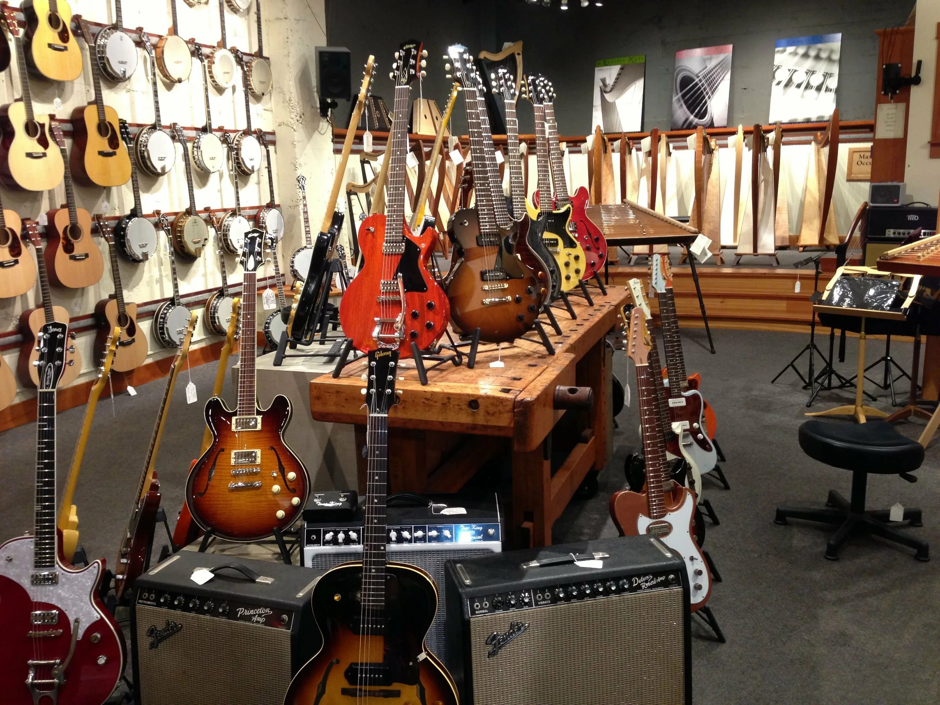 Купить гитару в магазине гитарный клуб. Гитарный магазин. Гитары музыкальные магазины. Витрина для гитары. Интерьер музыкального магазина.