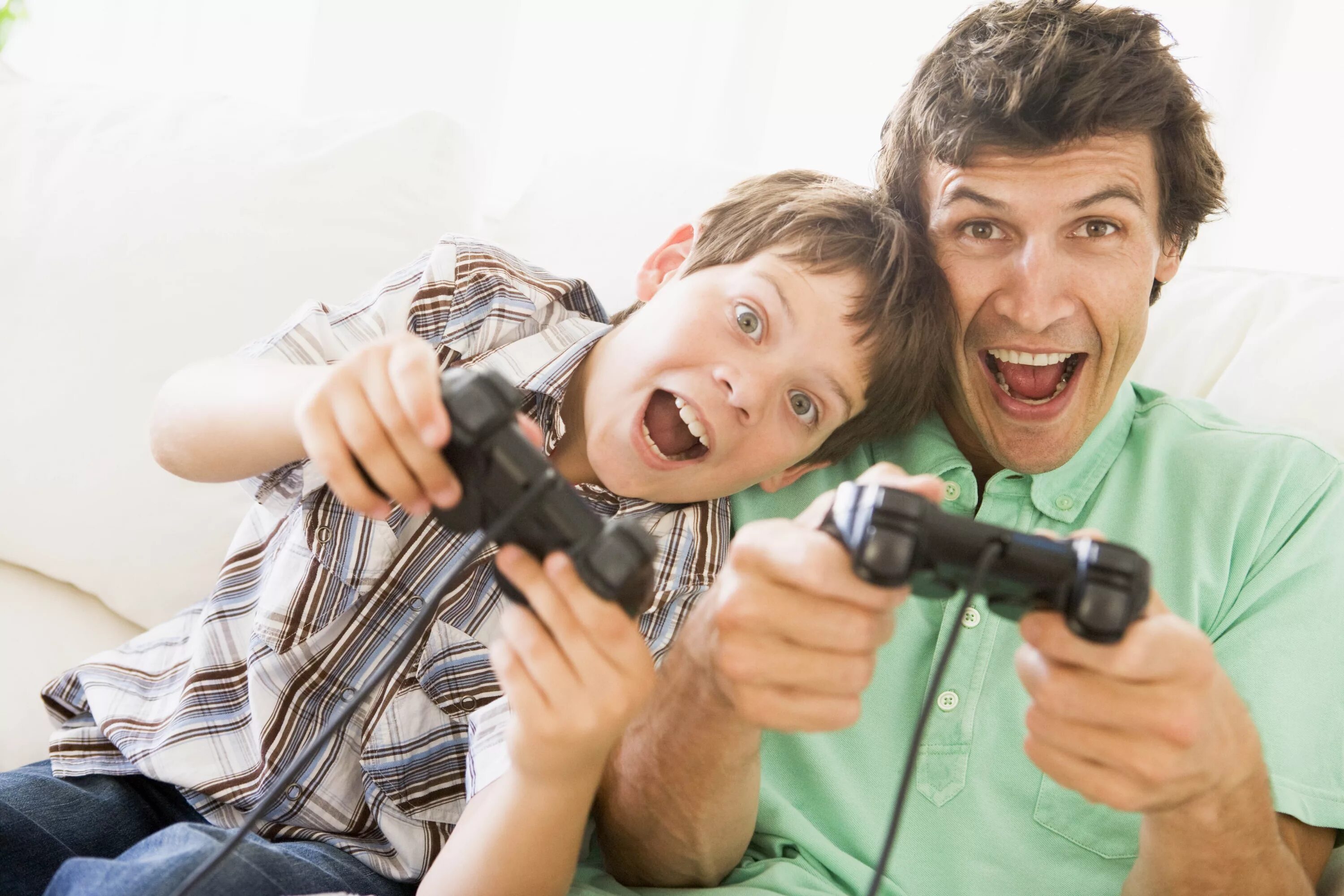 Играть в видеоигры. Отец и сын. Дети играющие в Видеоигры. Мужчина играет с детьми. Радостные дети и компьютерные игры.