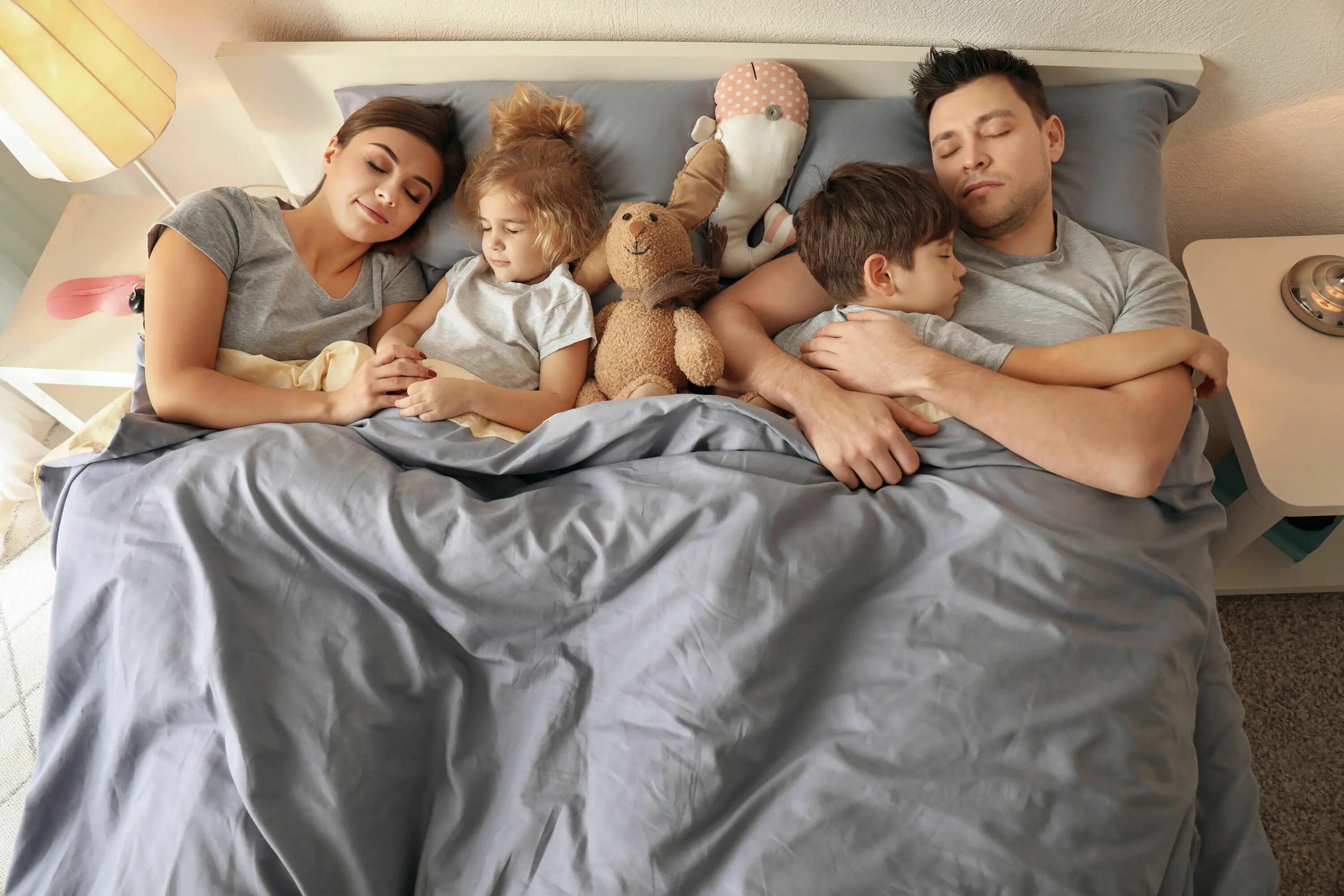 Семья на кровати. Сон всей семьи. Четверо спящих
