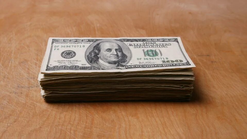 Your money on the table. Dollars on table. stack of dollars. stack of money on the table.