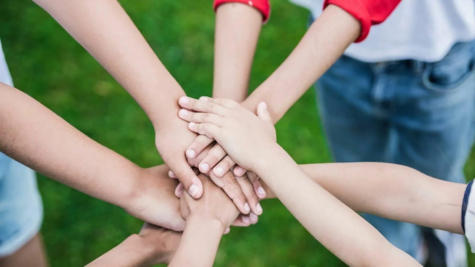 Дети соединили руки. Детские руки в кругу. Молодые люди, соединяющие руки. Люди кладут руки друг на друга. Руки соединены вместе.