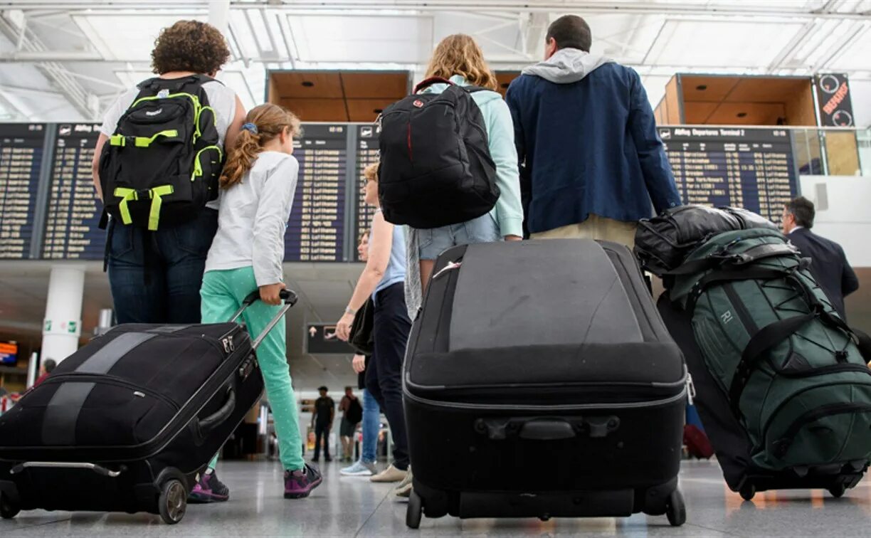 Первое путешествие за границу. Человек с багажом в аэропорту. Перевоз багажа. Пассажир с чемоданом. Чемодан в аэропорту.