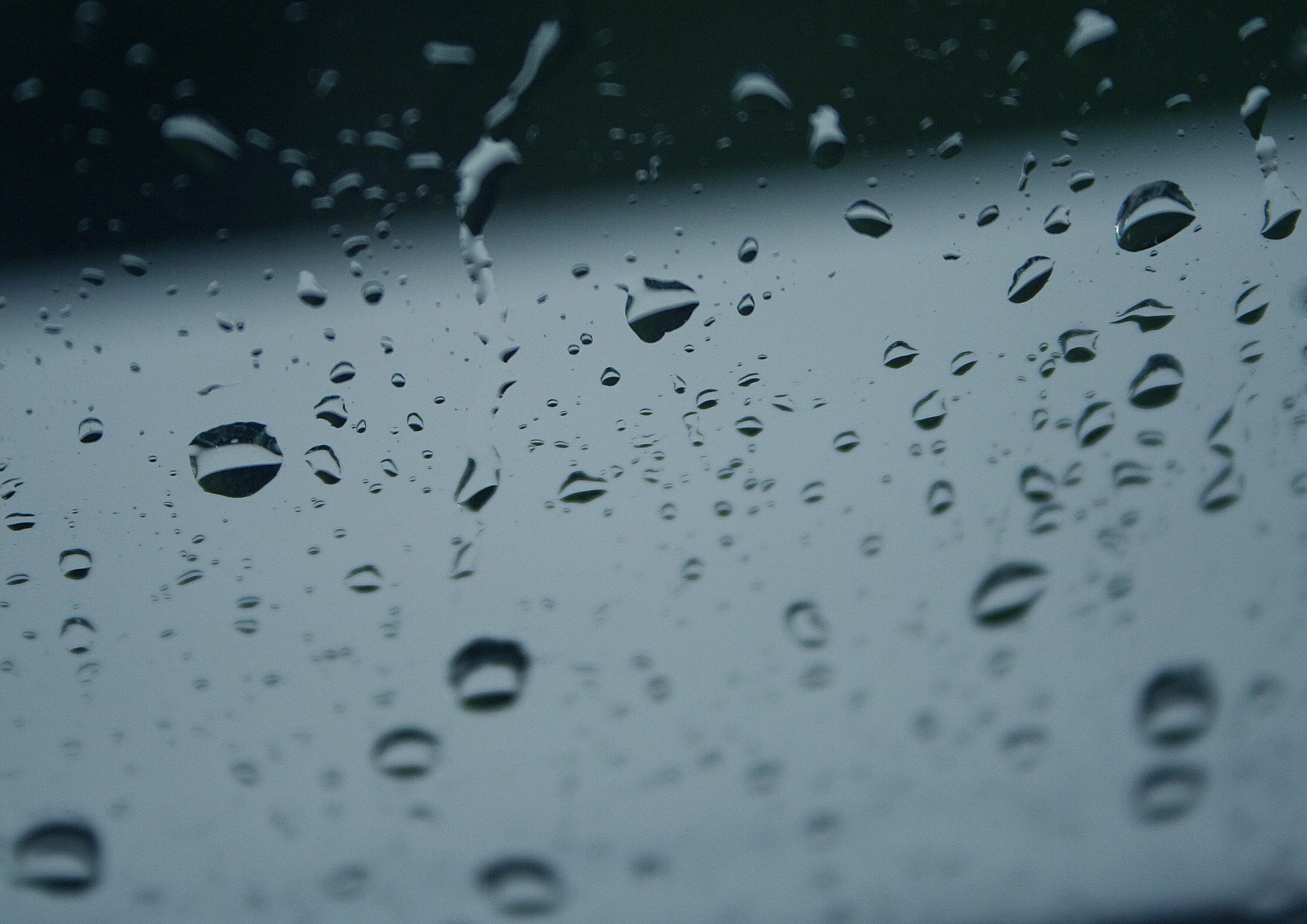 Крупные капли дождя падали. Капли дождя. Капли на стекле. Капли на окне. Белые капли.
