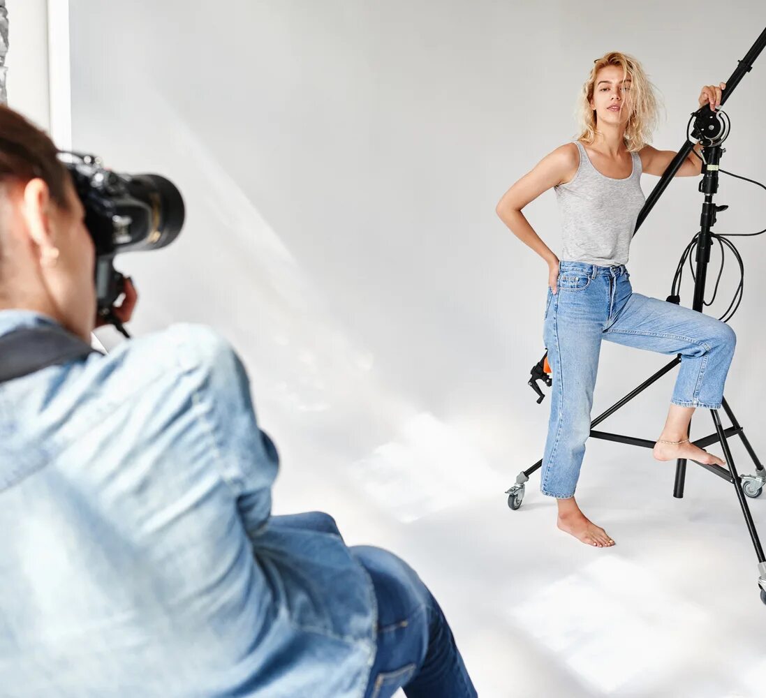 Фотограф и фотомодель. Позирую фотографу. Девушка позирует фотографу в студии. Фотограф фотографирует девушку. Фотомодель на съемках.