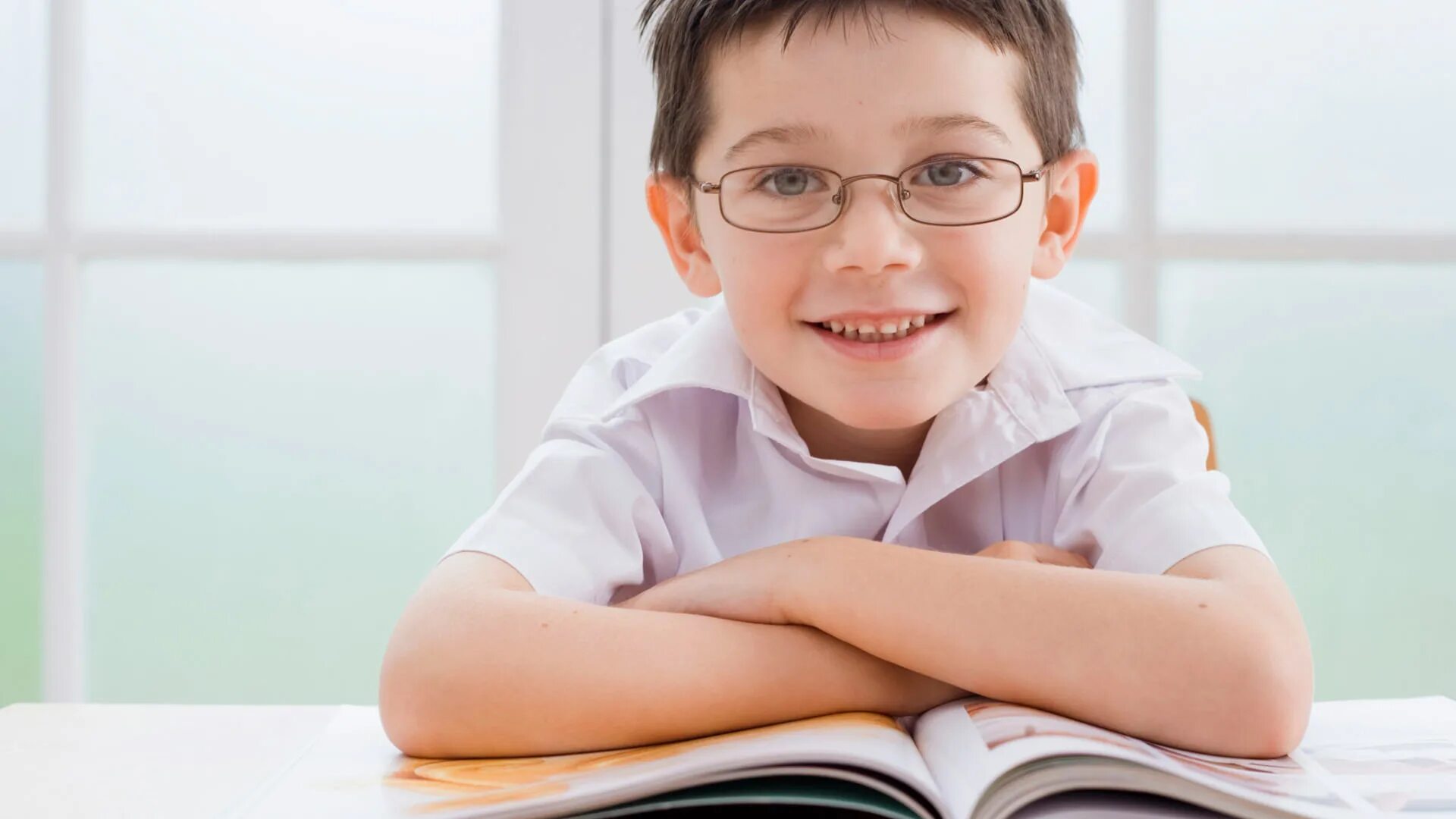 Школьная память. Дети в очках. Милый малыш в очках решает задачу. Ребенок учится читать.
