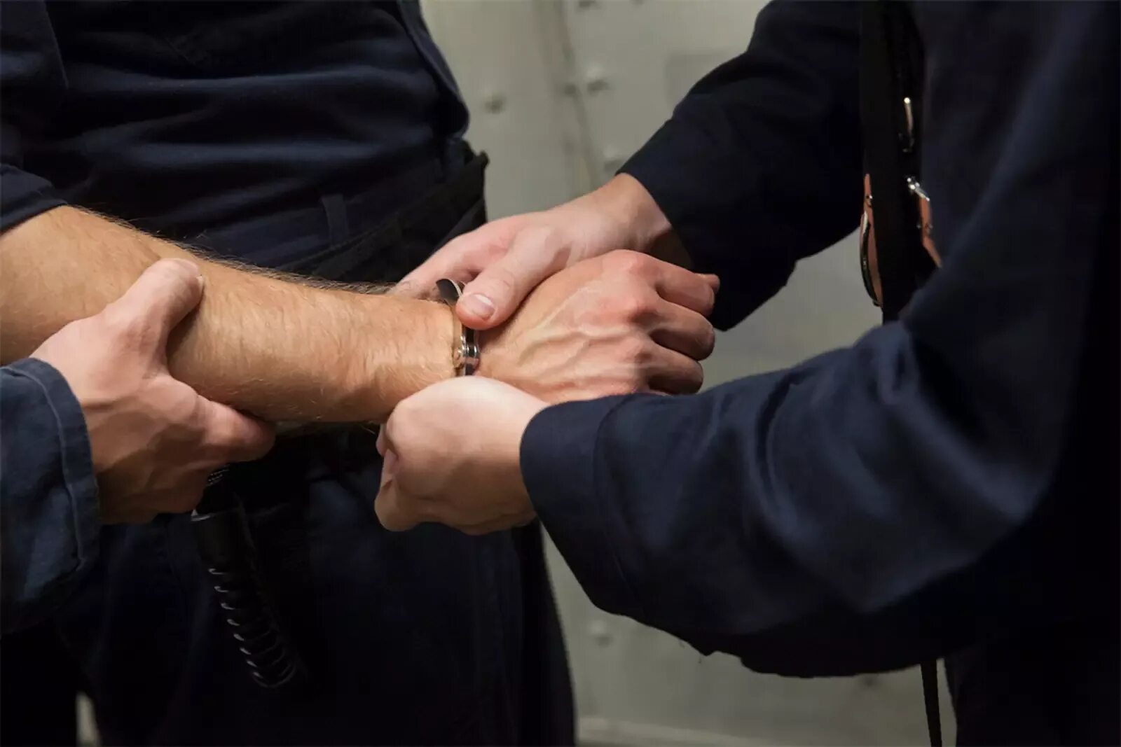 Полиция наручники. Полицейский надевает наручники. Задержанный в наручниках. Полиция наручники задержание.