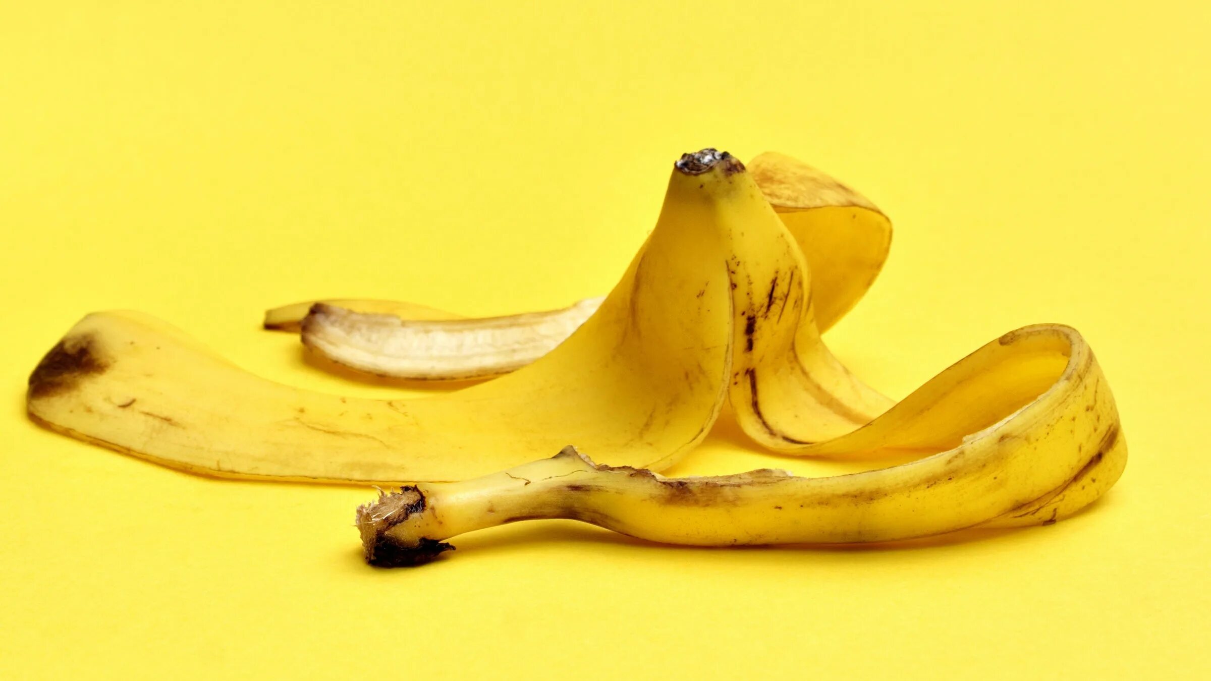 Как называется кожура. Шкурка банана. Банановая кожура. Банан на желтом фоне.