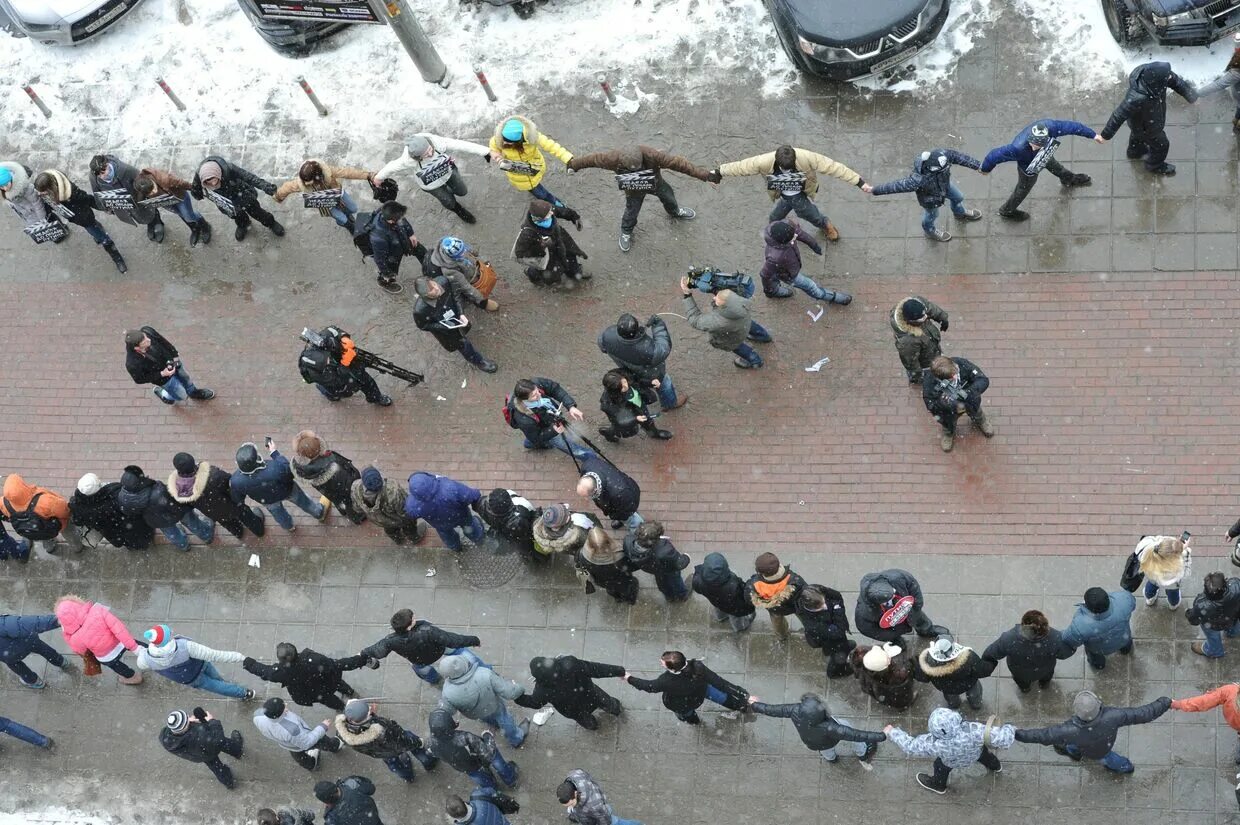 В круг выстроились 27 островитян. В круг выстроились 27 островитян. Люди в кругу сверху. Флэшмоб вместе. Люди выстраиваются в фигуры.