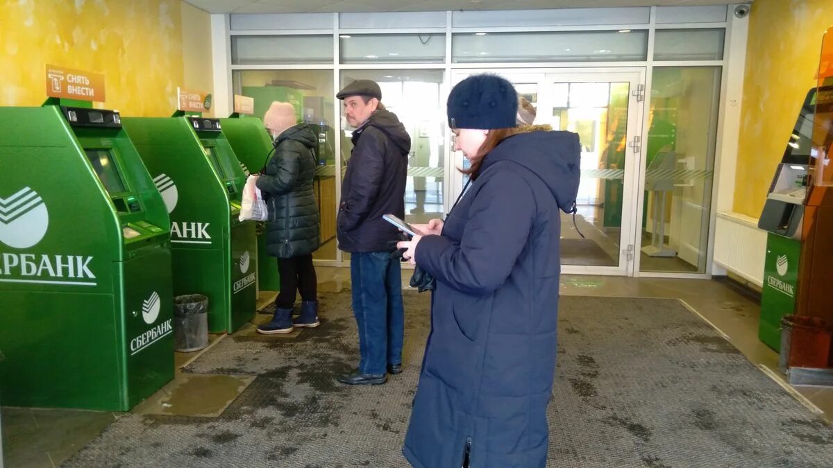 Люди стоят у электронных банкоматов фото.