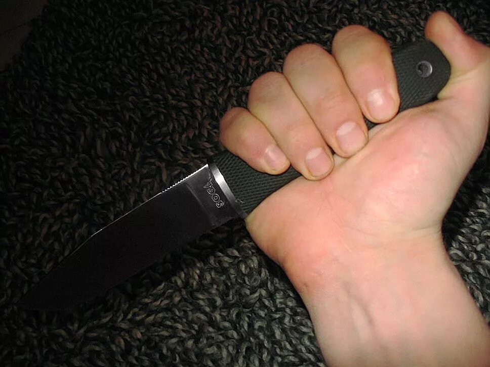 нож в руке в темноте