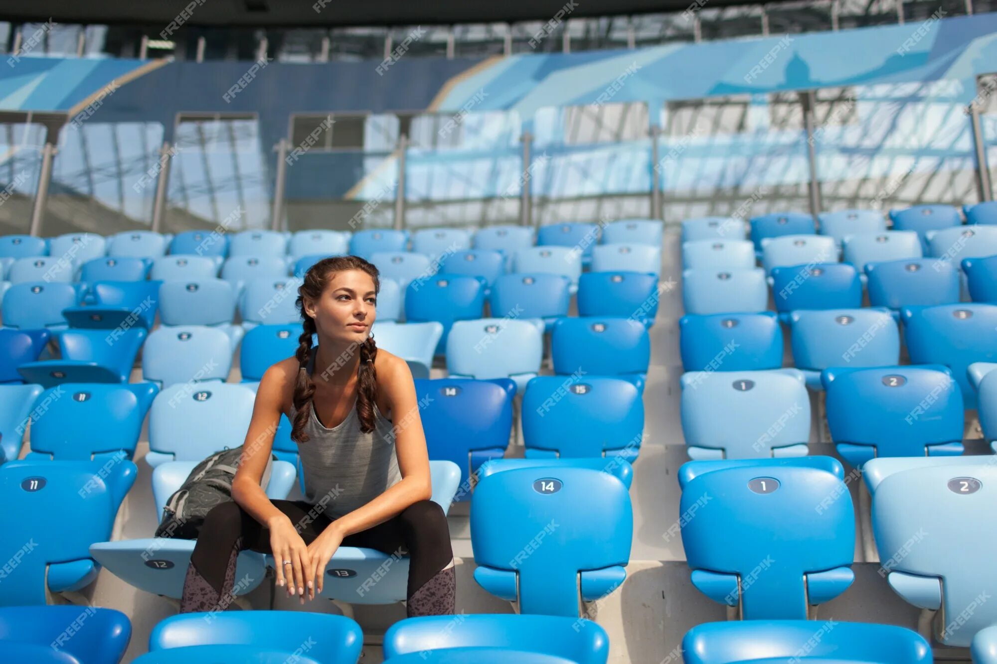 Женщина на стадионе. Женщины на стадионе. Сиденья на стадионе. Сидят на стадионе. Фотосессия девушек на стадионе сидя.