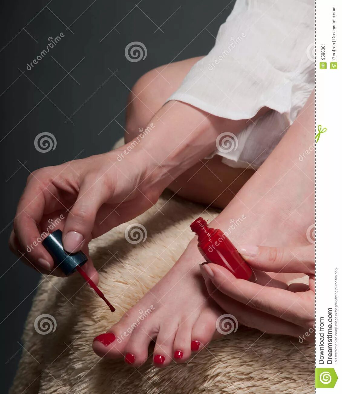 Красивые руки с маникюром с красным лаком. Женщина красит ногти на ногах. Босая госпожа. Женские ступни в туфлях. Госпожа с длинными ногтями.