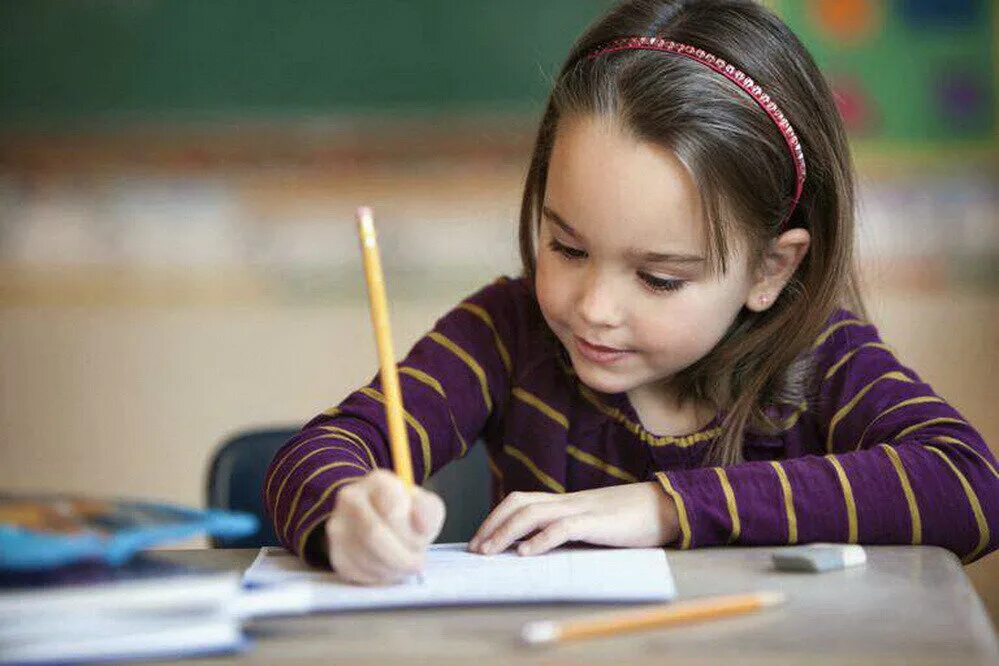 Ребенок пишет. Старательный ученик. Ребенок учится писать. Девочка карандашом.