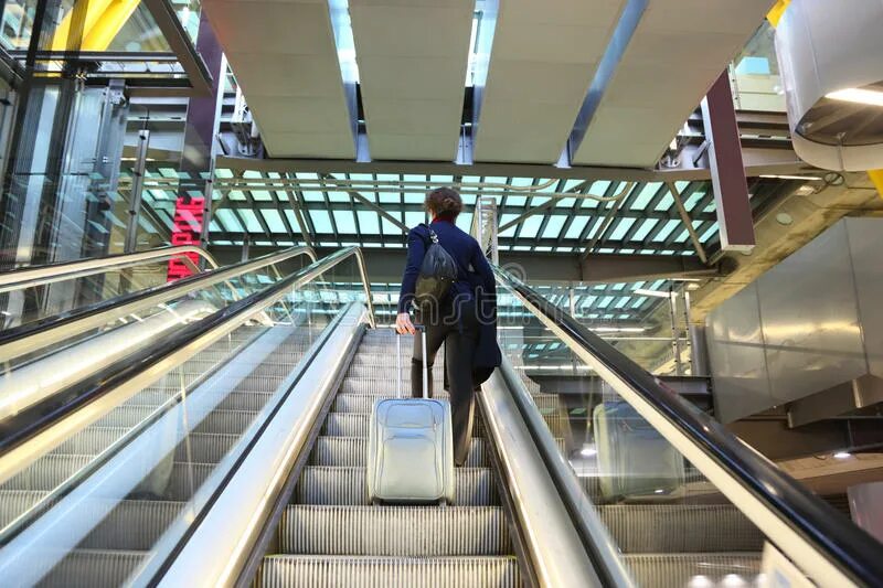 Эскалатор метрополитена поднимает стоящего. Эскалатор в аэропорту. Эскалатор и чемоданы. Люди на эскалаторе. Эскалатор в аэропорту для чемоданов.