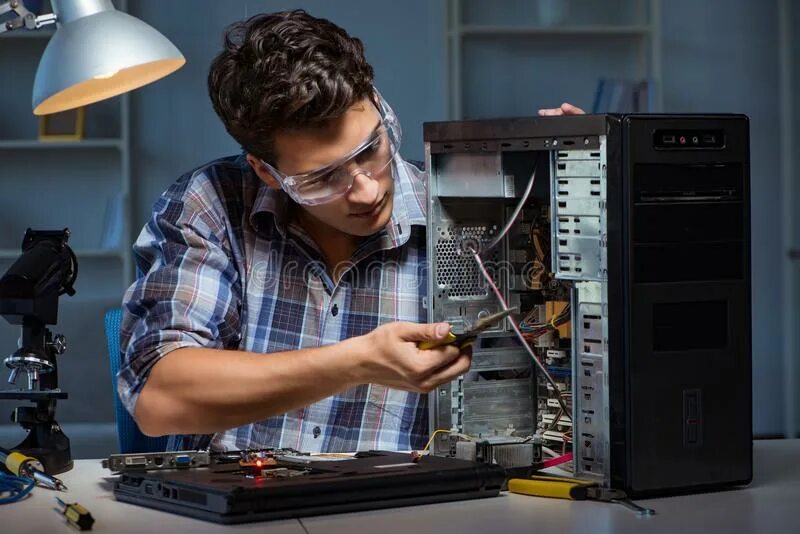 Компьютер. Компьютерный мастер чинит. Ремонтирует компьютер. Мужчина чинит компьютер.