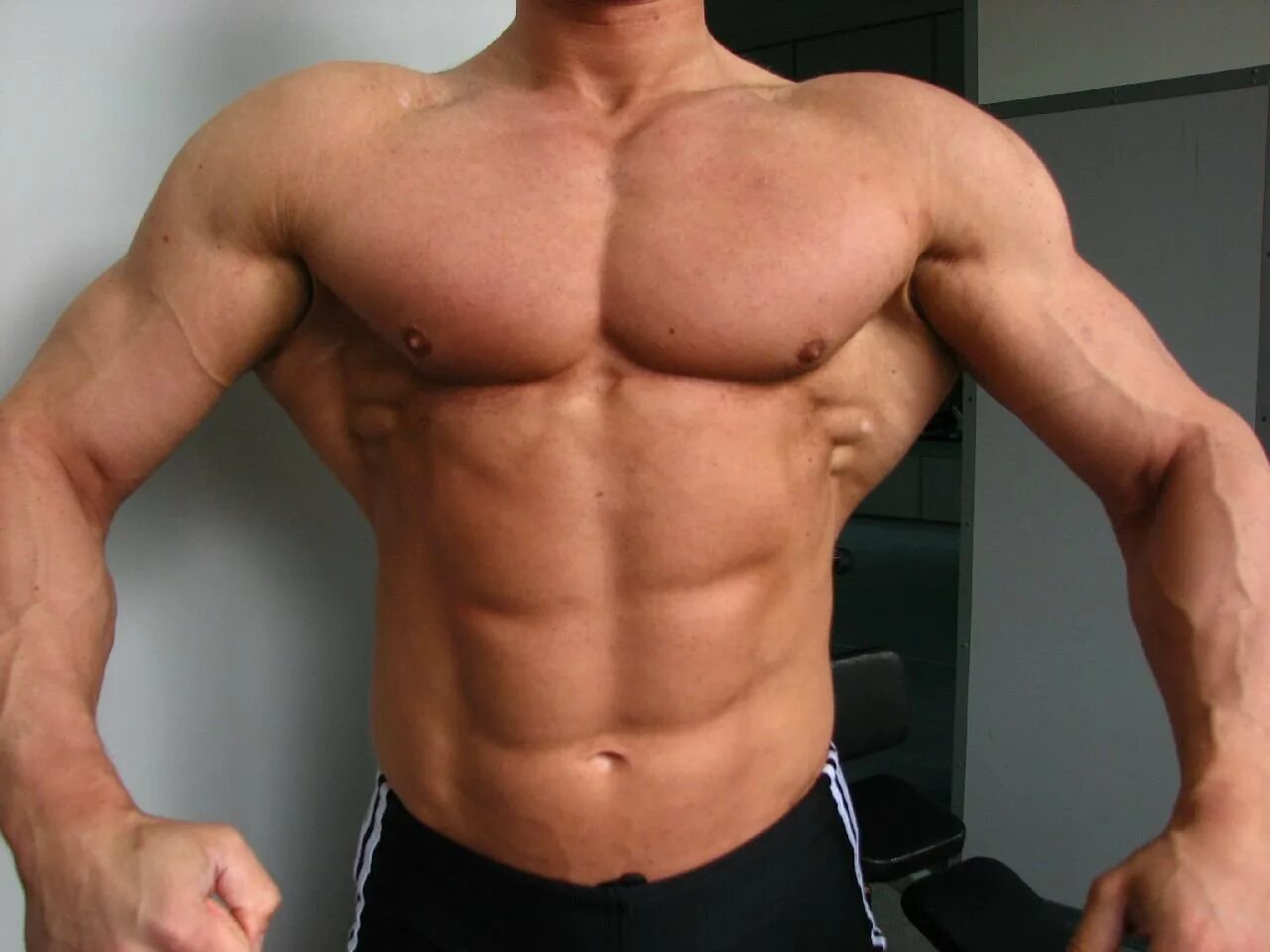 Кубики бицепс. Спортивное тело мужчины. Мускулистый мужчина. Мощные плечи. Крылья мышцы.