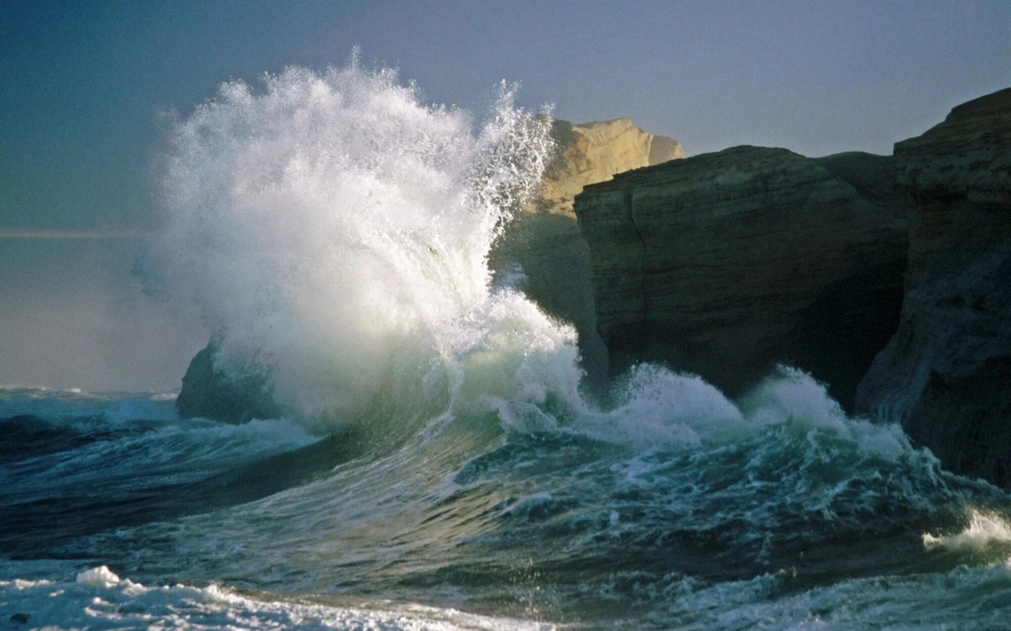 Первыми приходят волны. Волны бьются о скалы. Волны разбиваются о скалы. Море шторм. Атлантический океан.
