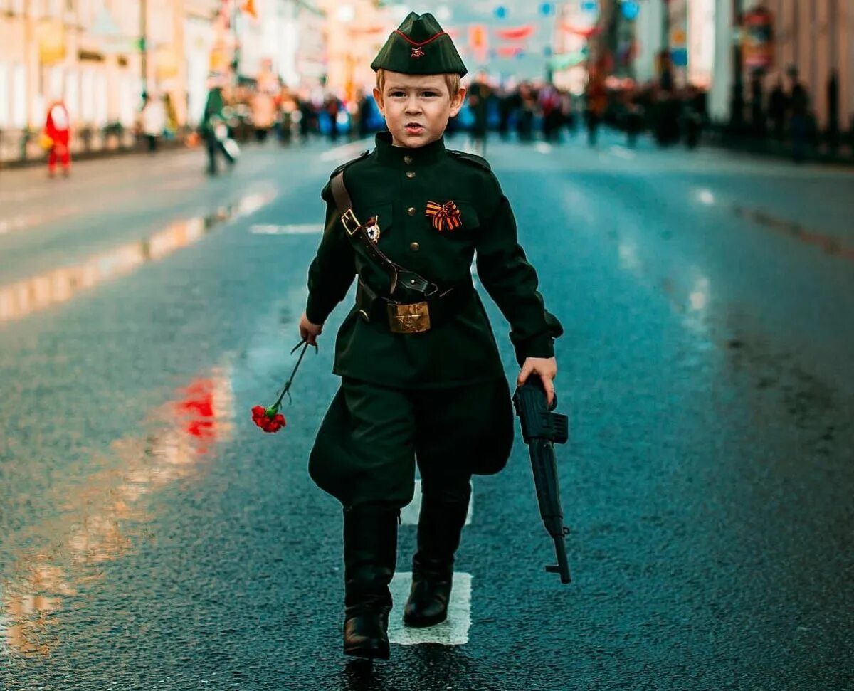 Мальчик на дне победы. Мальчик в военной форме. Мальчишки в военной форме. Солдат по городу. Дети на параде Победы.