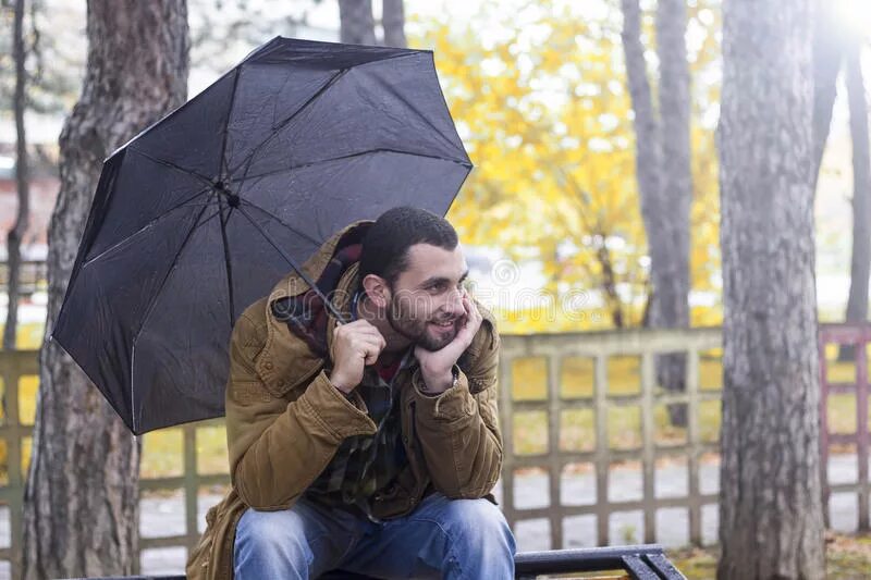 Зонтик сидит. Человек на лавочке держит зонт. Сидит с зонтом. Фонарь держит зонтик над скамейкой. Парень сидит с зонтом поза.