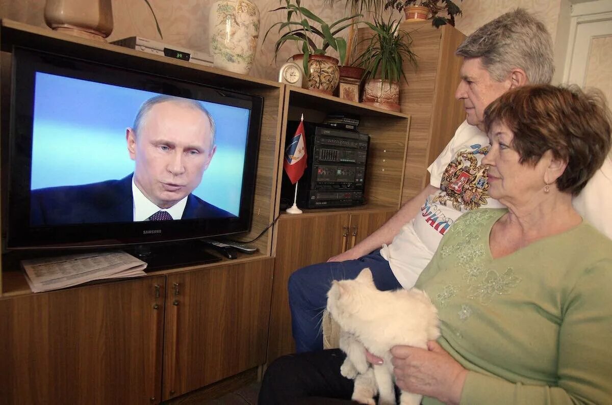 Бабушка у телевизора с Путиным.