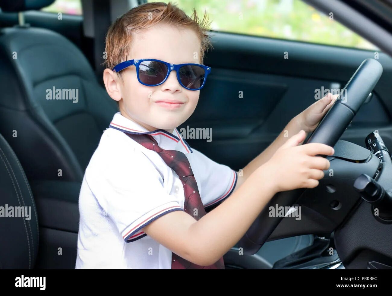 Small driver. Мальчик в крутом машине за рулем. брат сидит в машине. driver boy. старший и младший брат в солнцезащитных очках.