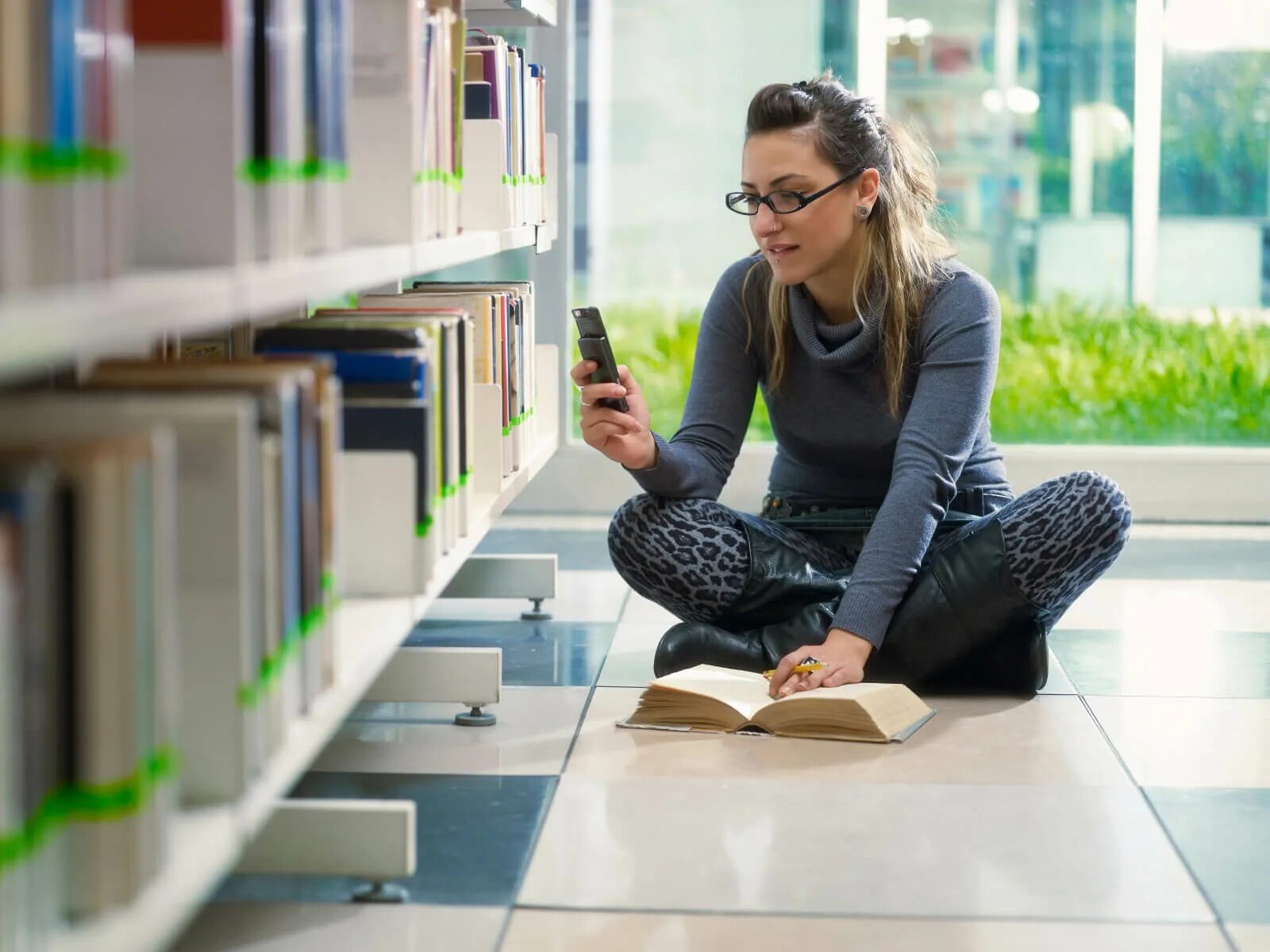 Young library. Студенты в библиотеке. Современный читатель. Сидит в библиотеке. Человек сидит в библиотеке.