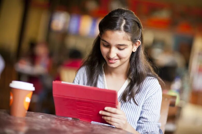 Beautiful student. Beautiful student girl. Pupil girl. Serious student. In the shop listening