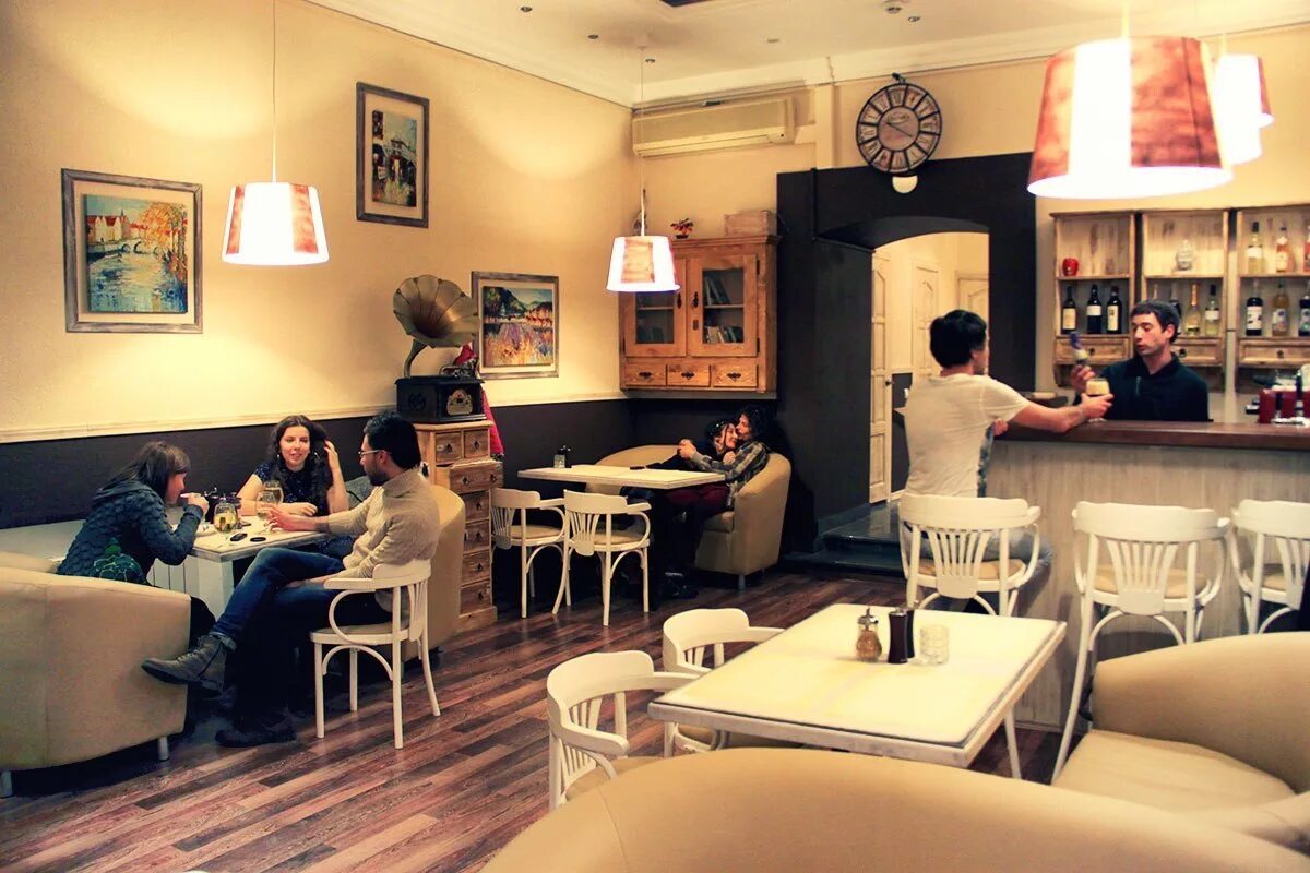 Интерьер кафе с людьми. Маленькое уютное кафе. Люди в кафе. Люди в кофейне.