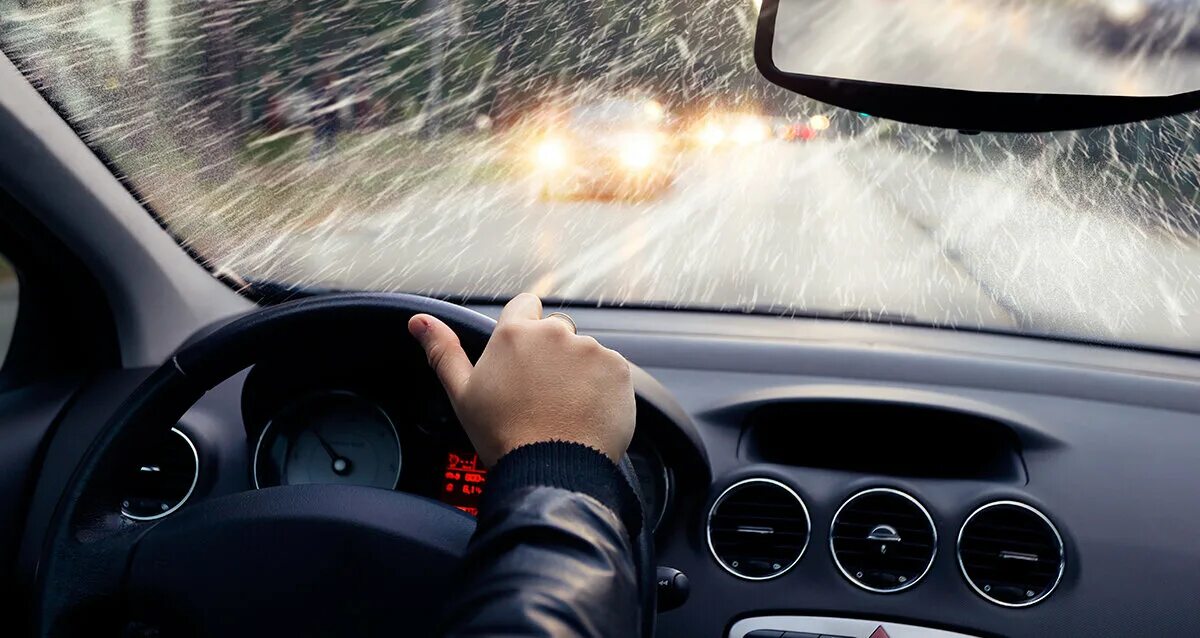 Хорошо в машине в дождь. Безопасное вождение. За рулем автомобиль ливень. Лобовое стекло изнутри. Вождение в дождь.