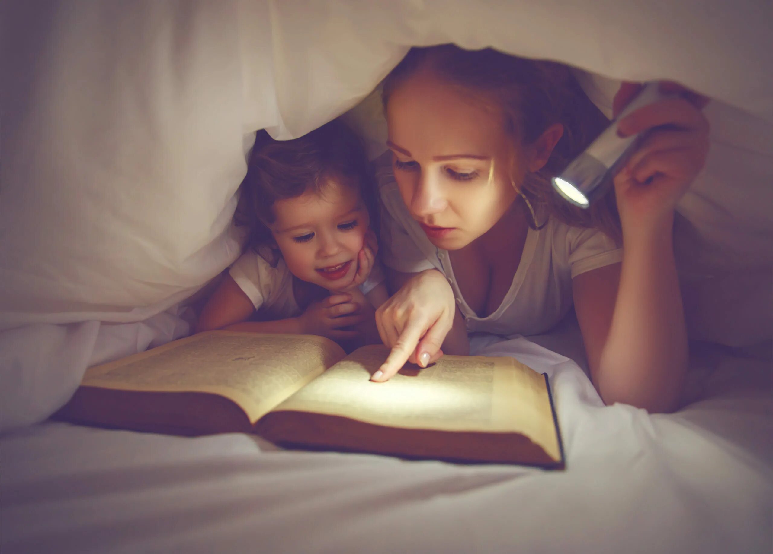 Чтение перед сном. Чтение под одеялом с фонариком. Мама с книжкой и ребенком. Фотосессия мама читает дочке.