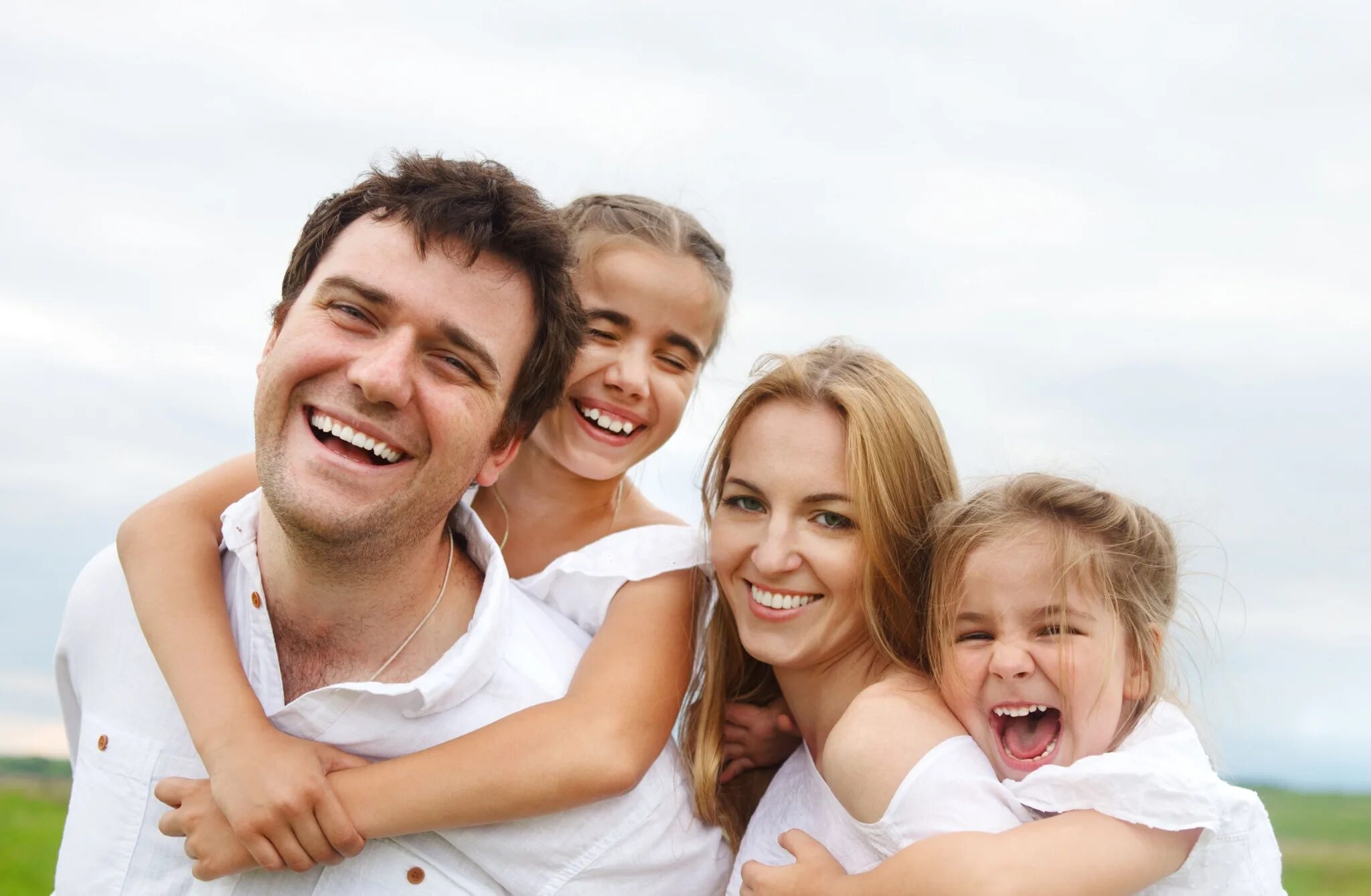 Счастливая семья. Семья улыбается. Фотография семьи. Счастливая семья улыбается. Ребенок двух людей